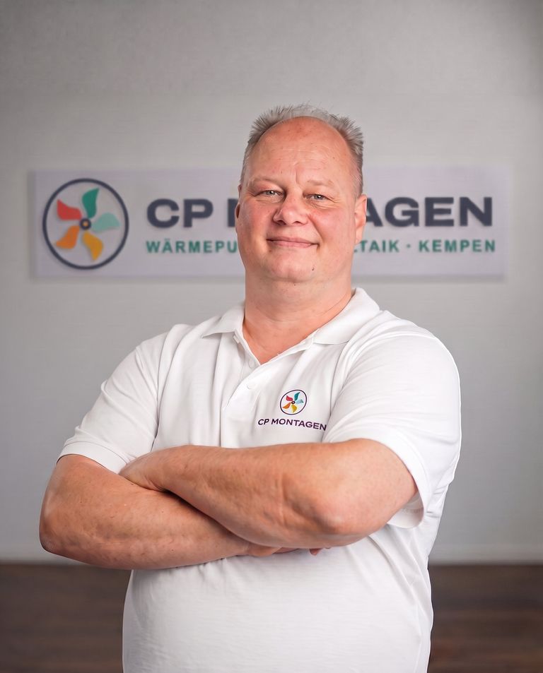Carsten Päplow, Inhaber von CP Montagen, mit verschränkten Armen vor dem Firmenlogo